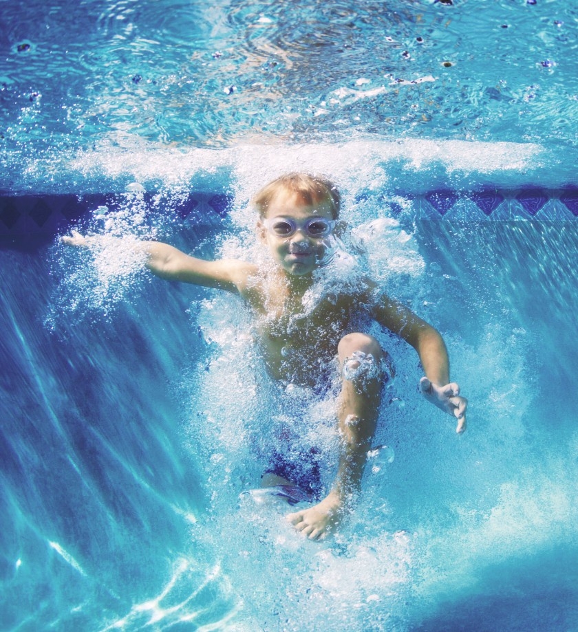 Little boy plunging in pool water